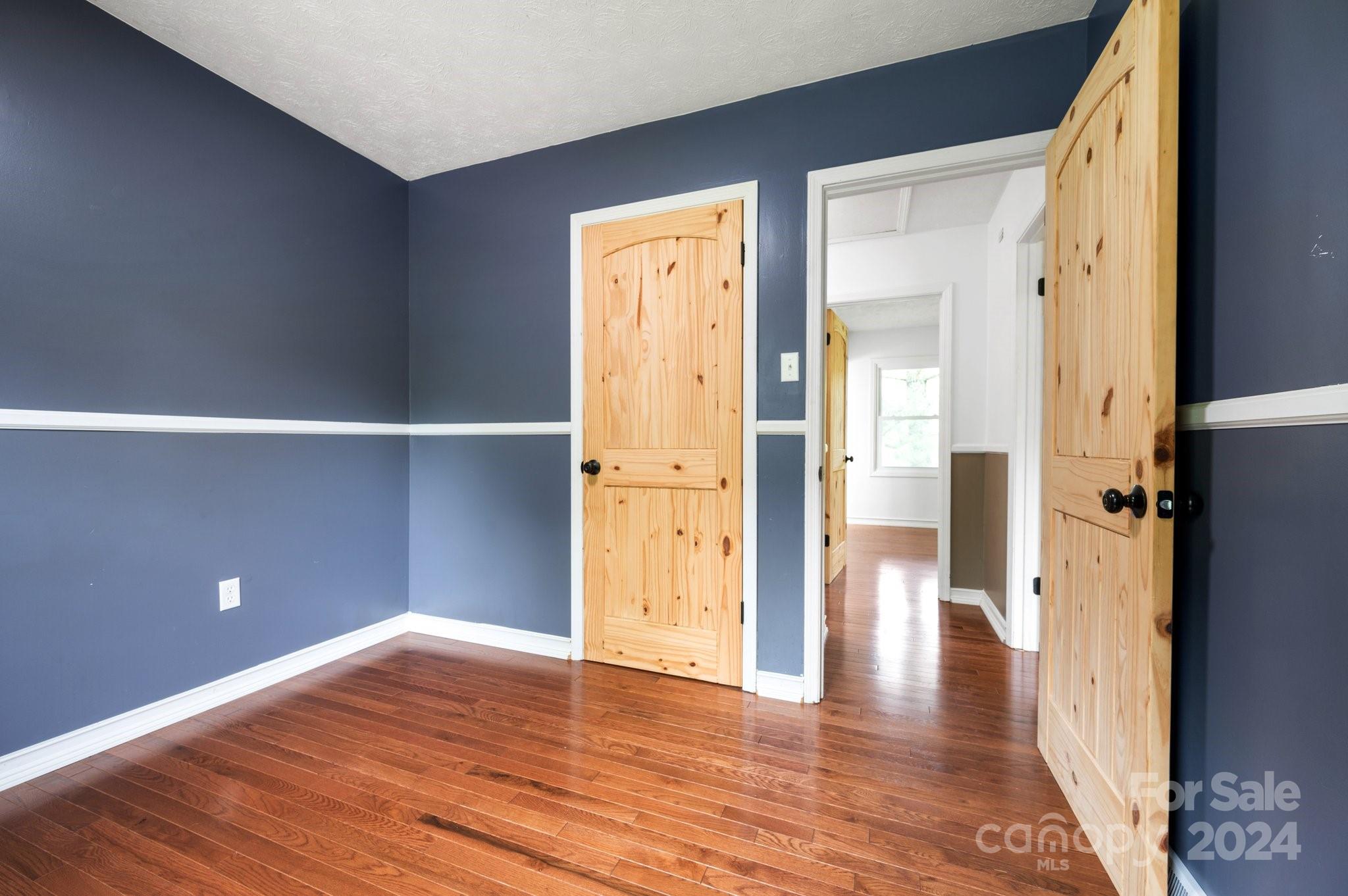 12 South Ridge Place Arden, NC 28704 - Photo 18 of 41 a view of an empty room with wooden floor and a bathroom