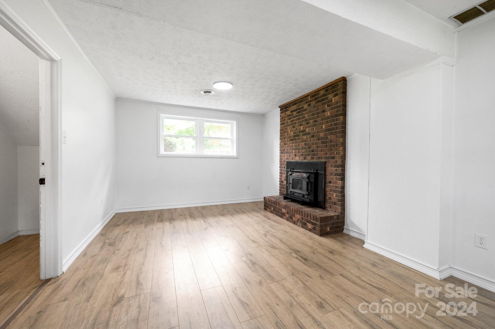 12 South Ridge Place Arden, NC 28704 - Photo 22 of 41 an empty room with wooden floor fireplace and windows