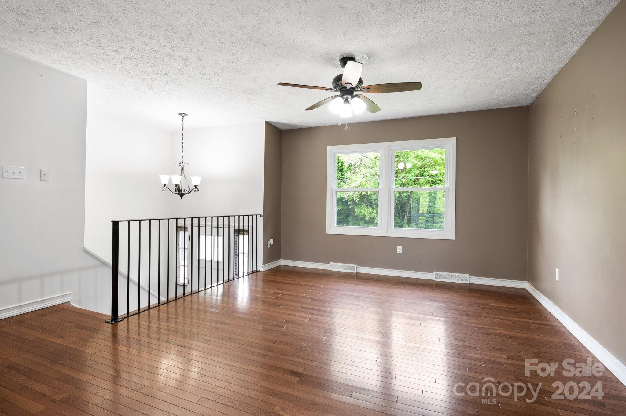12 South Ridge Place Arden, NC 28704 - Photo 5 of 41 an empty room with wooden floor fan and windows
