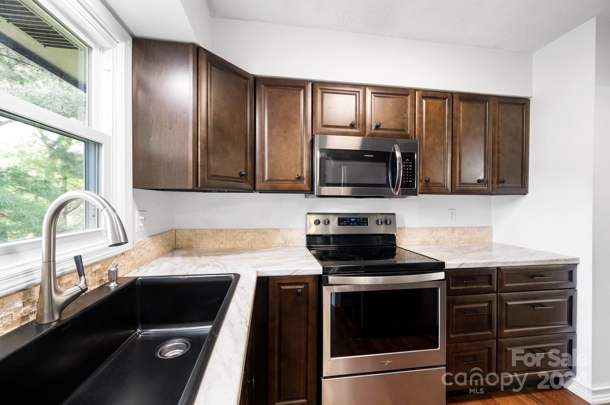 12 South Ridge Place Arden, NC 28704 - Photo 10 of 41 a kitchen with granite countertop a stove and a microwave with cabinets