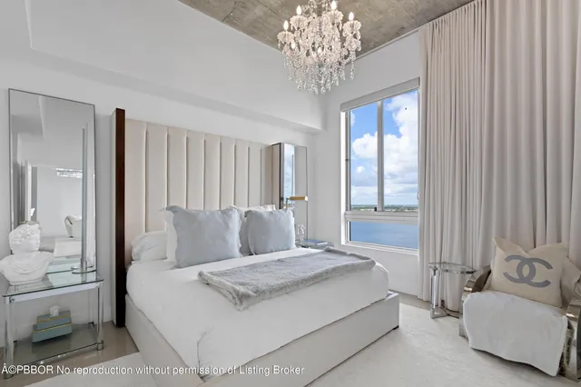 a spacious bedroom with a bed and a chandelier