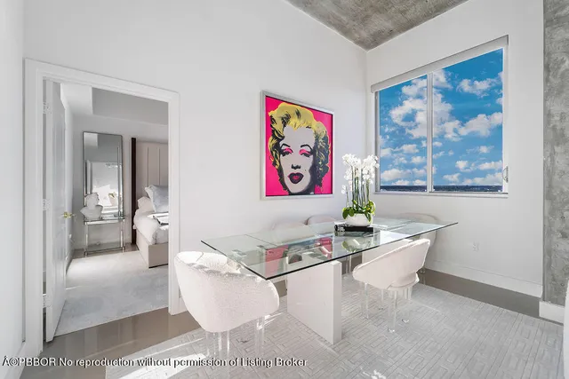 a living room with furniture and a painting on the wall