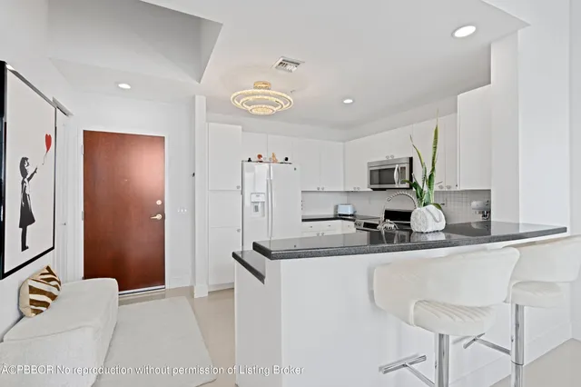 a kitchen with stainless steel appliances granite countertop a sink and a refrigerator