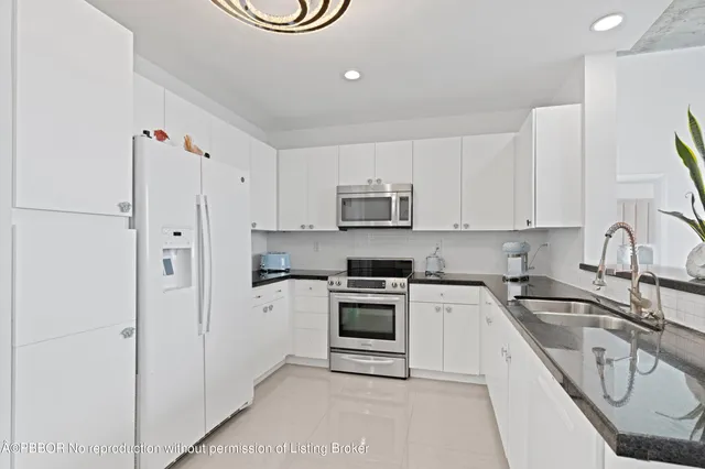 a kitchen with white cabinets and white appliances