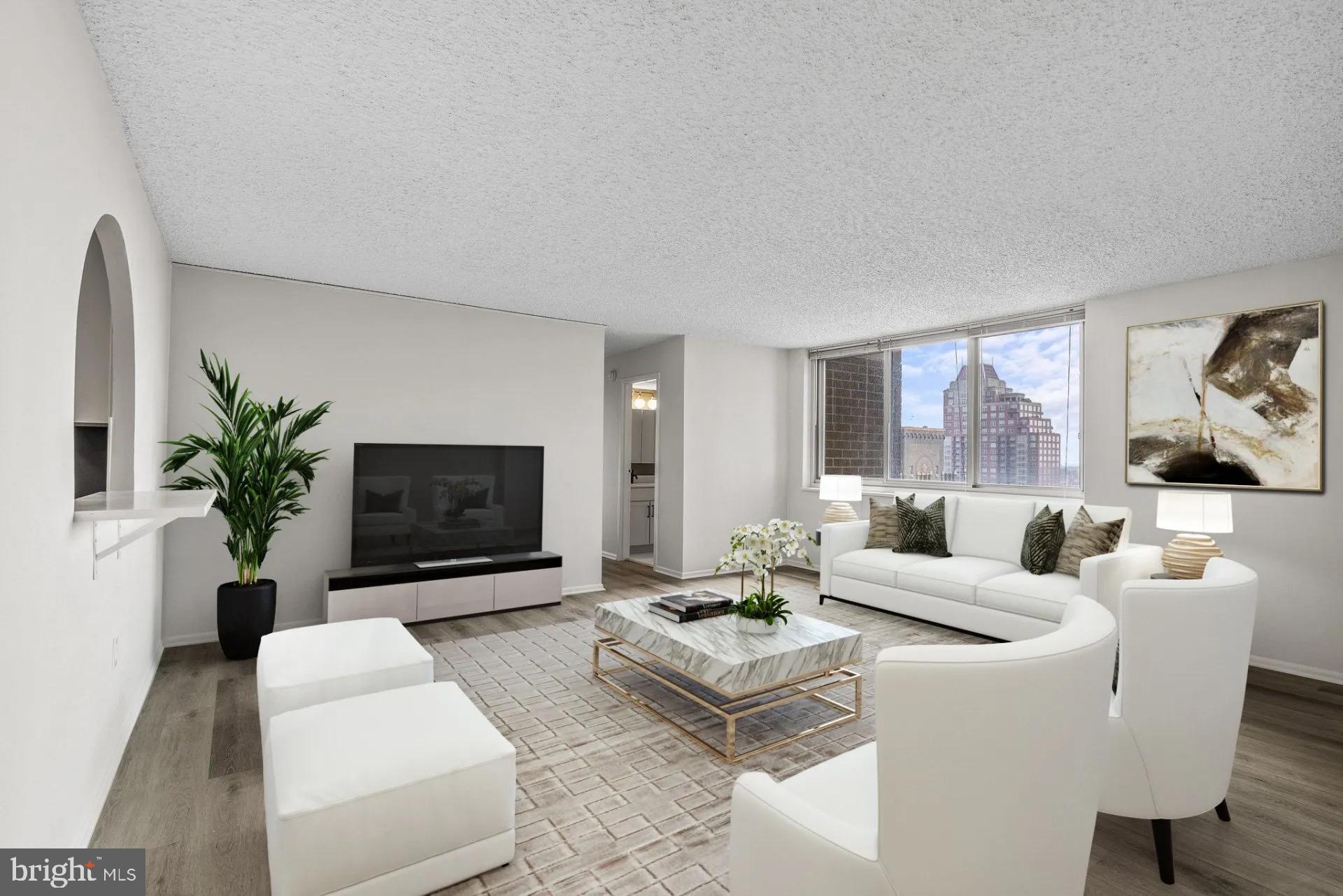1500 Locust Street, Unit 2B2413 Philadelphia, PA 19102 - Photo 6 of 25 a living room with furniture a flat screen tv and a potted plant