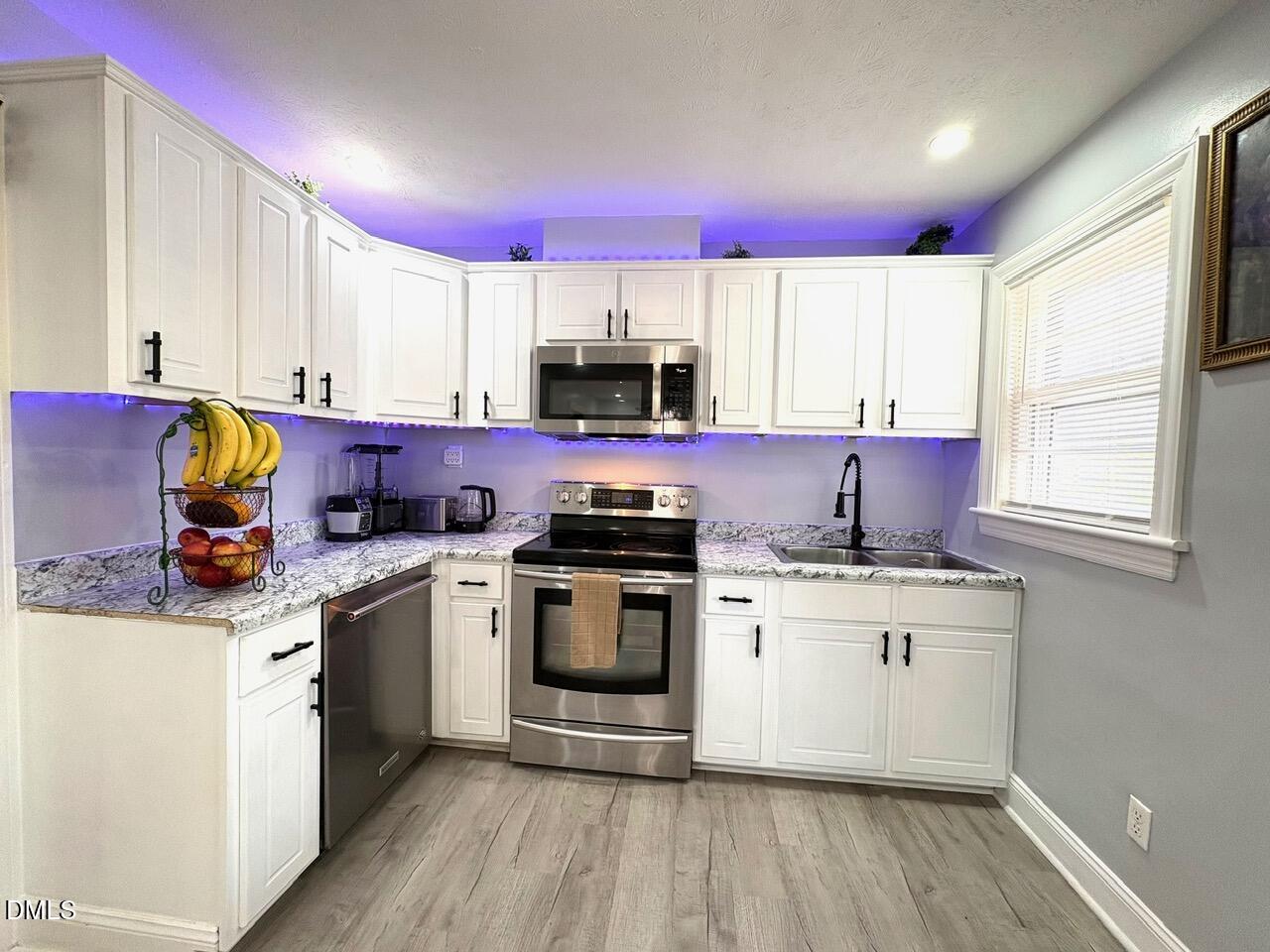 1337 Maple Street Rocky Mount, NC 27803 - Photo 2 of 15 a kitchen with stainless steel appliances a sink a stove a microwave a refrigerator and cabinets