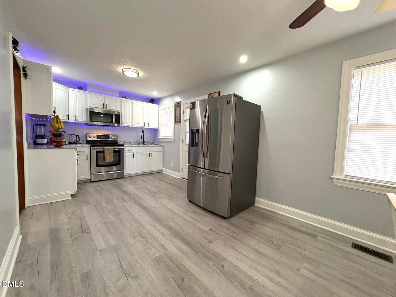 1337 Maple Street Rocky Mount, NC 27803 - Photo 3 of 15 a kitchen with a refrigerator a stove top oven a sink dishwasher and wooden floor