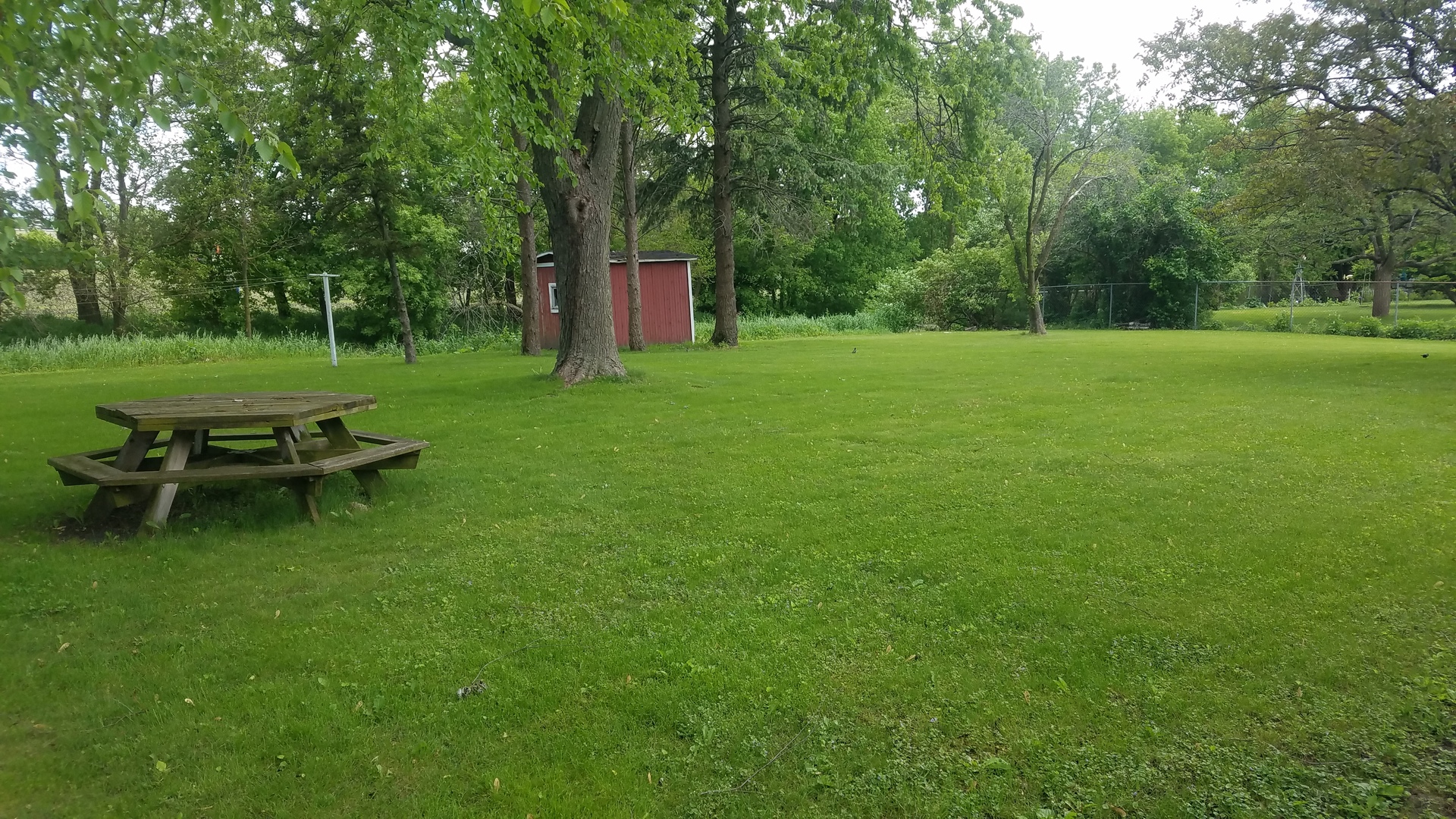 1401 Brookside Drive Rochelle, IL 61068 - Photo 4 of 20 a view of a wooden bench sitting in the grass near a house