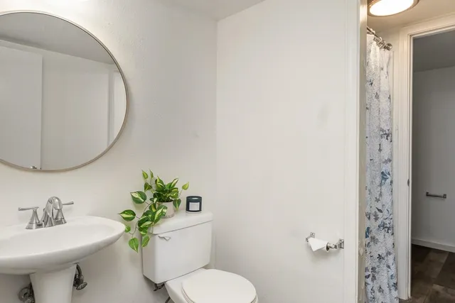 a bathroom with a sink toilet and a mirror