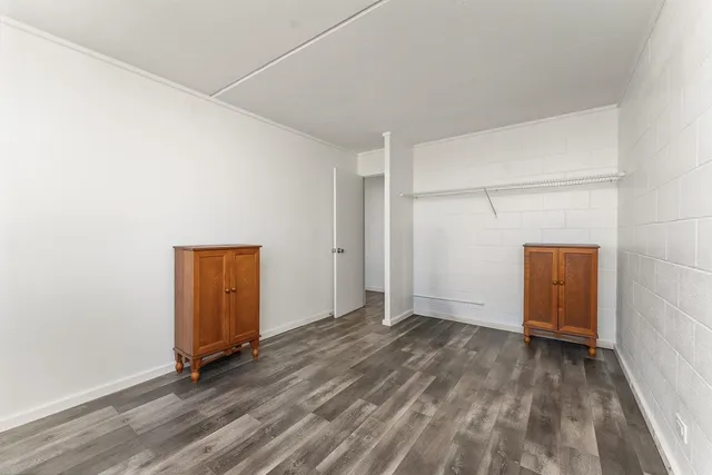 a view of an empty room with closet and a window