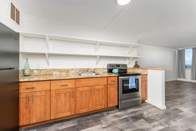 a kitchen with granite countertop a sink and a stove