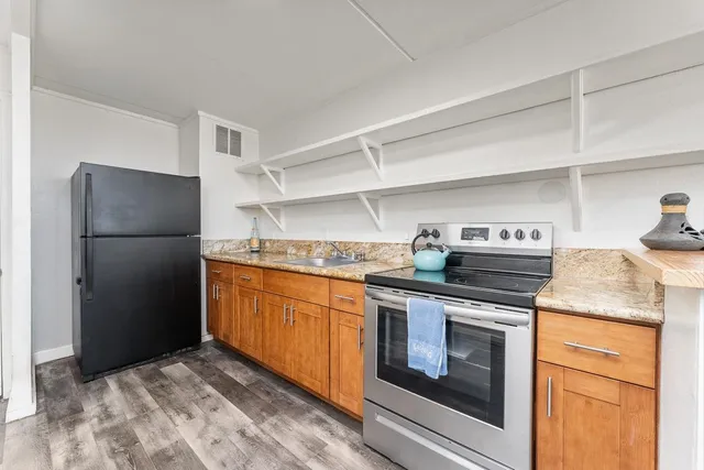 a kitchen with stainless steel appliances granite countertop a refrigerator stove and sink