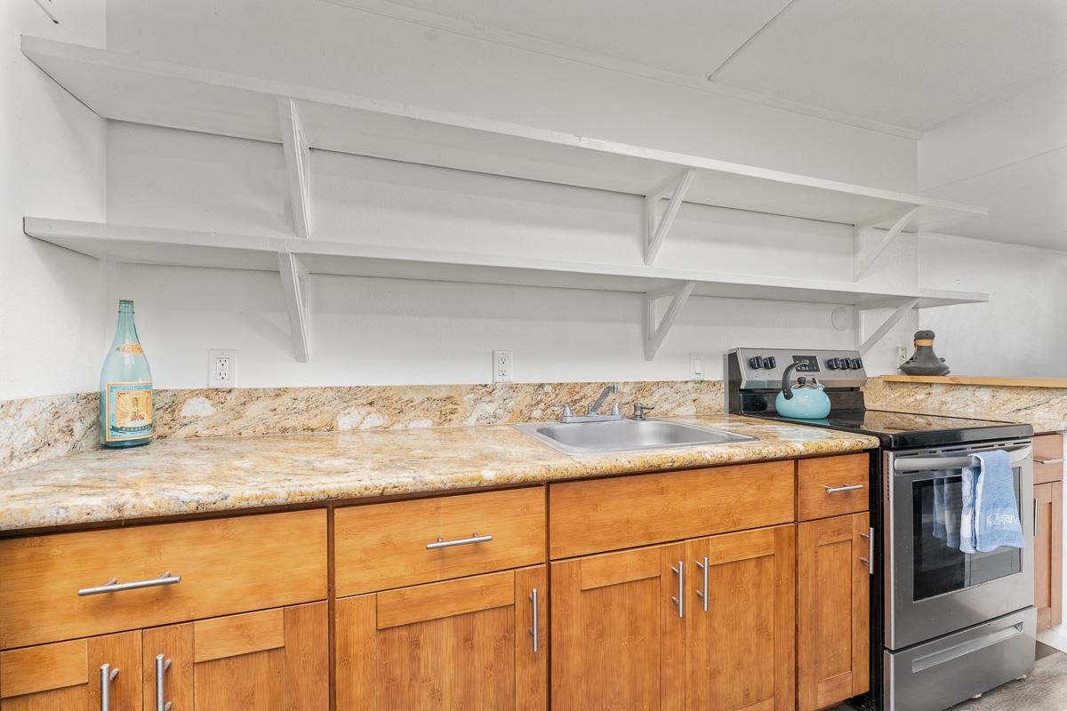 111 Kahului Beach Road, Unit A104 Kahului, HI 96732 - Photo 5 of 38 a kitchen with stainless steel appliances granite countertop a sink and cabinets