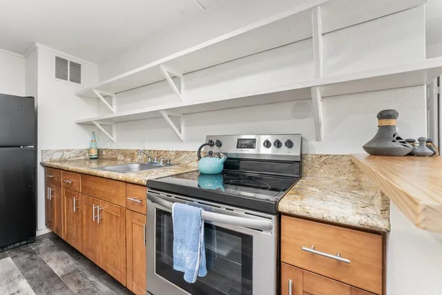 a kitchen with stainless steel appliances granite countertop a stove and a sink