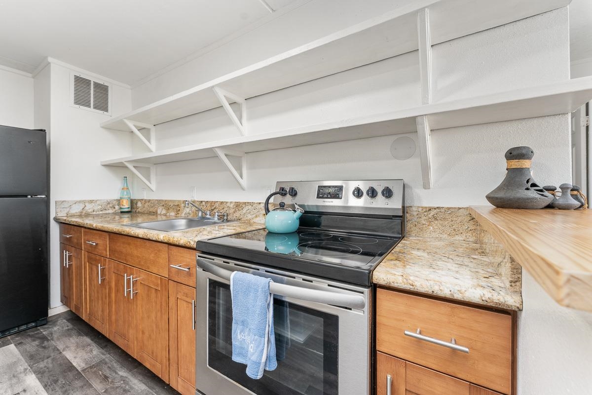 111 Kahului Beach Road, Unit A104 Kahului, HI 96732 - Photo 9 of 38 a kitchen with stainless steel appliances granite countertop a stove and a sink