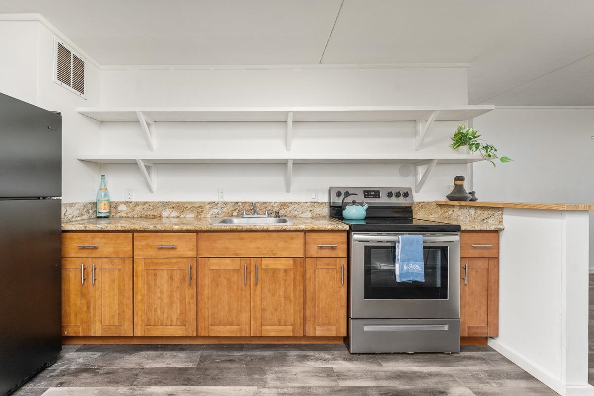 111 Kahului Beach Road, Unit A104 Kahului, HI 96732 - Photo 10 of 38 a kitchen with stainless steel appliances granite countertop a stove and a refrigerator