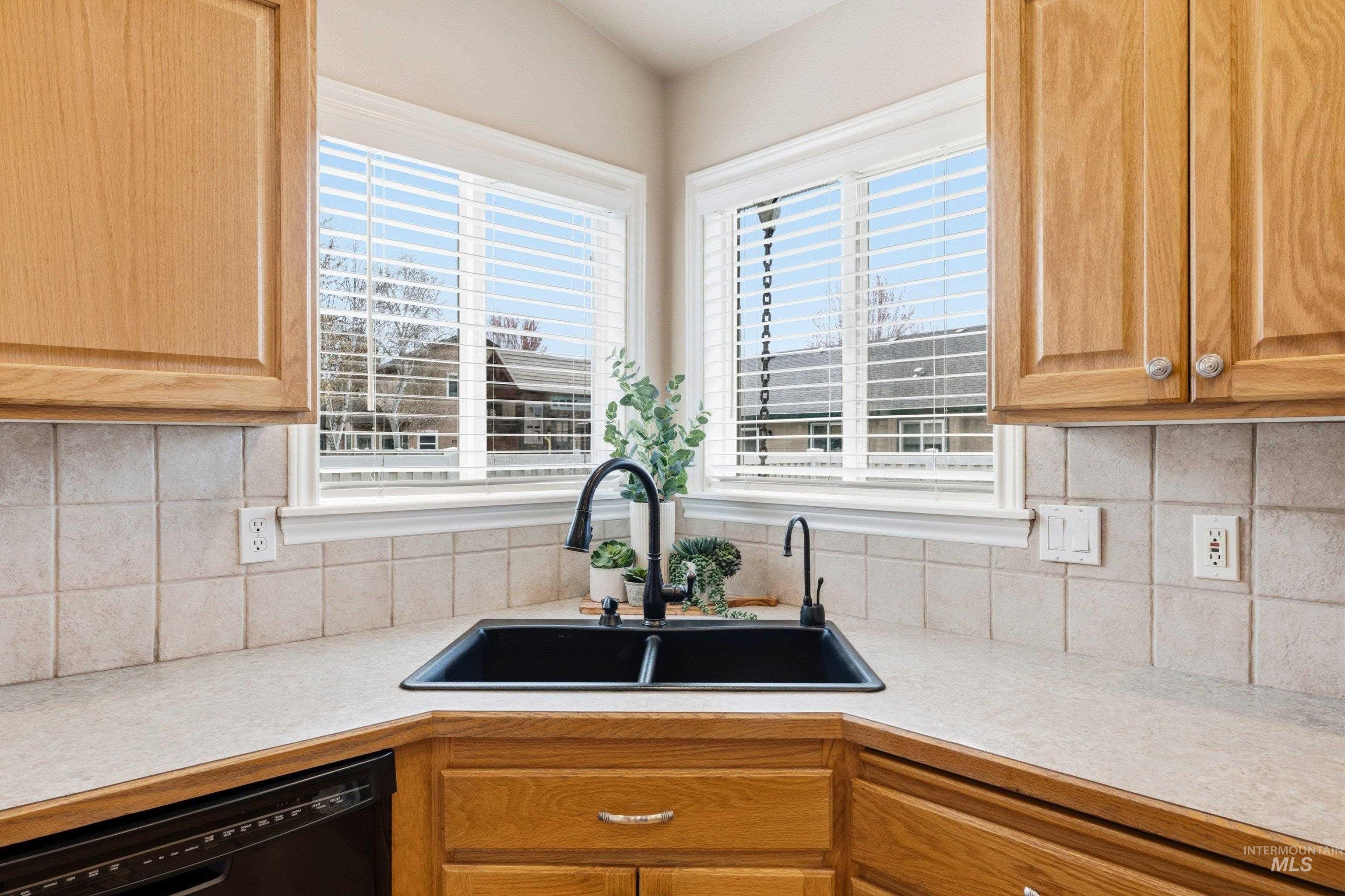 3787 North Alexis Way Meridian, ID 83646 - Photo 19 of 50 Kitchen featuring light countertops, black dishwasher, and decorative backsplash