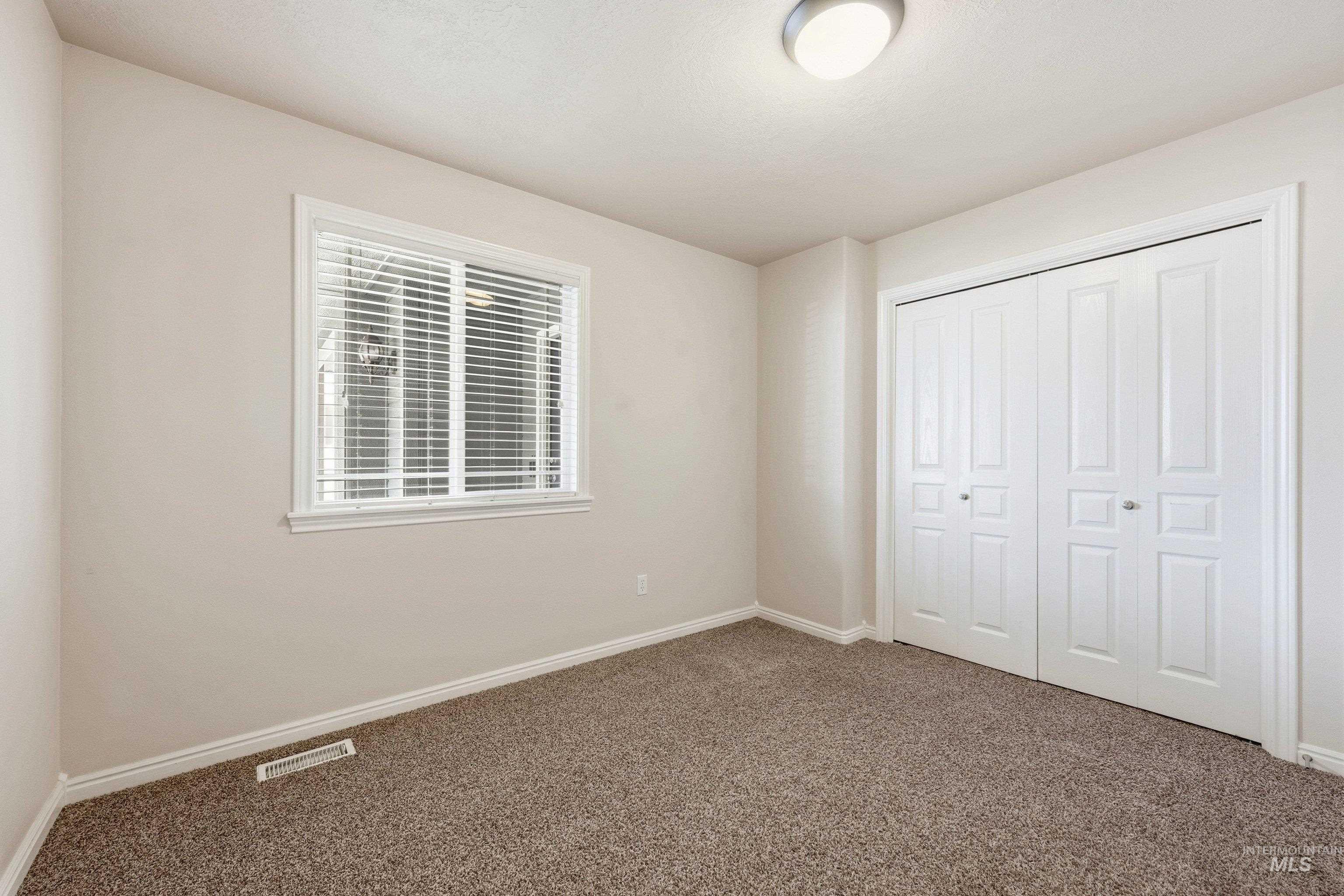 3787 North Alexis Way Meridian, ID 83646 - Photo 26 of 50 Unfurnished bedroom with dark carpet and a closet