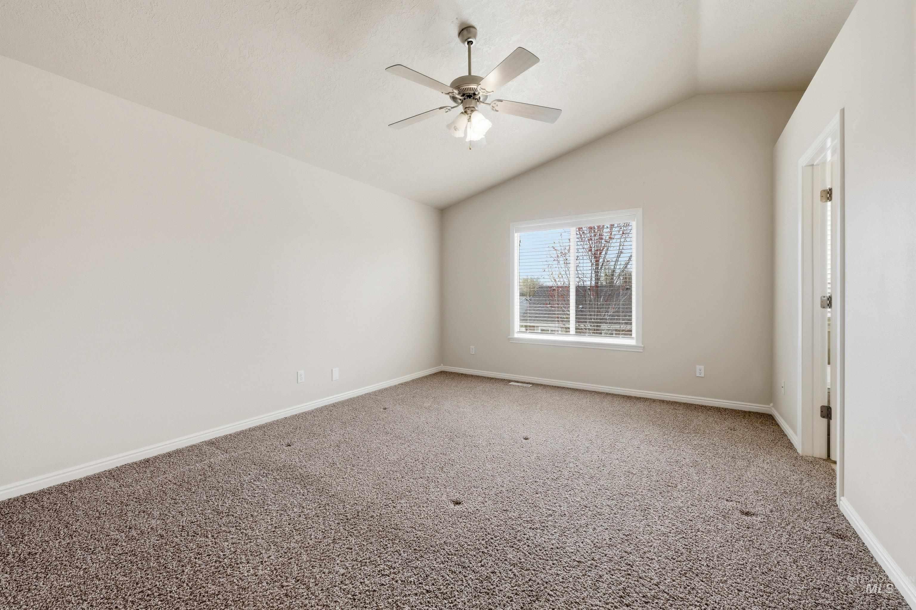 3787 North Alexis Way Meridian, ID 83646 - Photo 29 of 50 Unfurnished room with carpet flooring, vaulted ceiling, and a ceiling fan