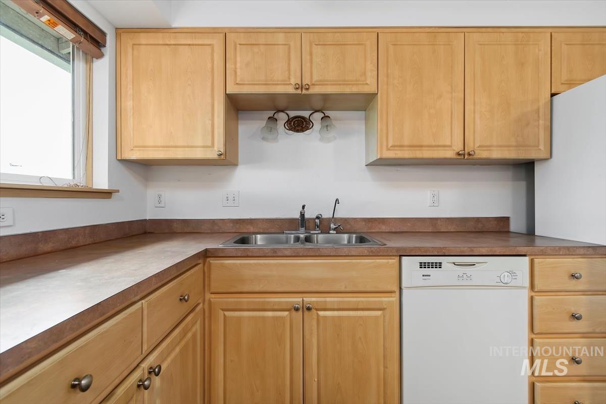 1051 Haas Road Weiser, ID 83672 - Photo 15 of 44 Kitchen featuring dishwasher, light wood finish cabinetry, freestanding refrigerator, and light countertops