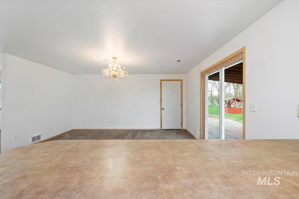 1051 Haas Road Weiser, ID 83672 - Photo 16 of 44 Unfurnished dining area featuring a chandelier and carpet floors