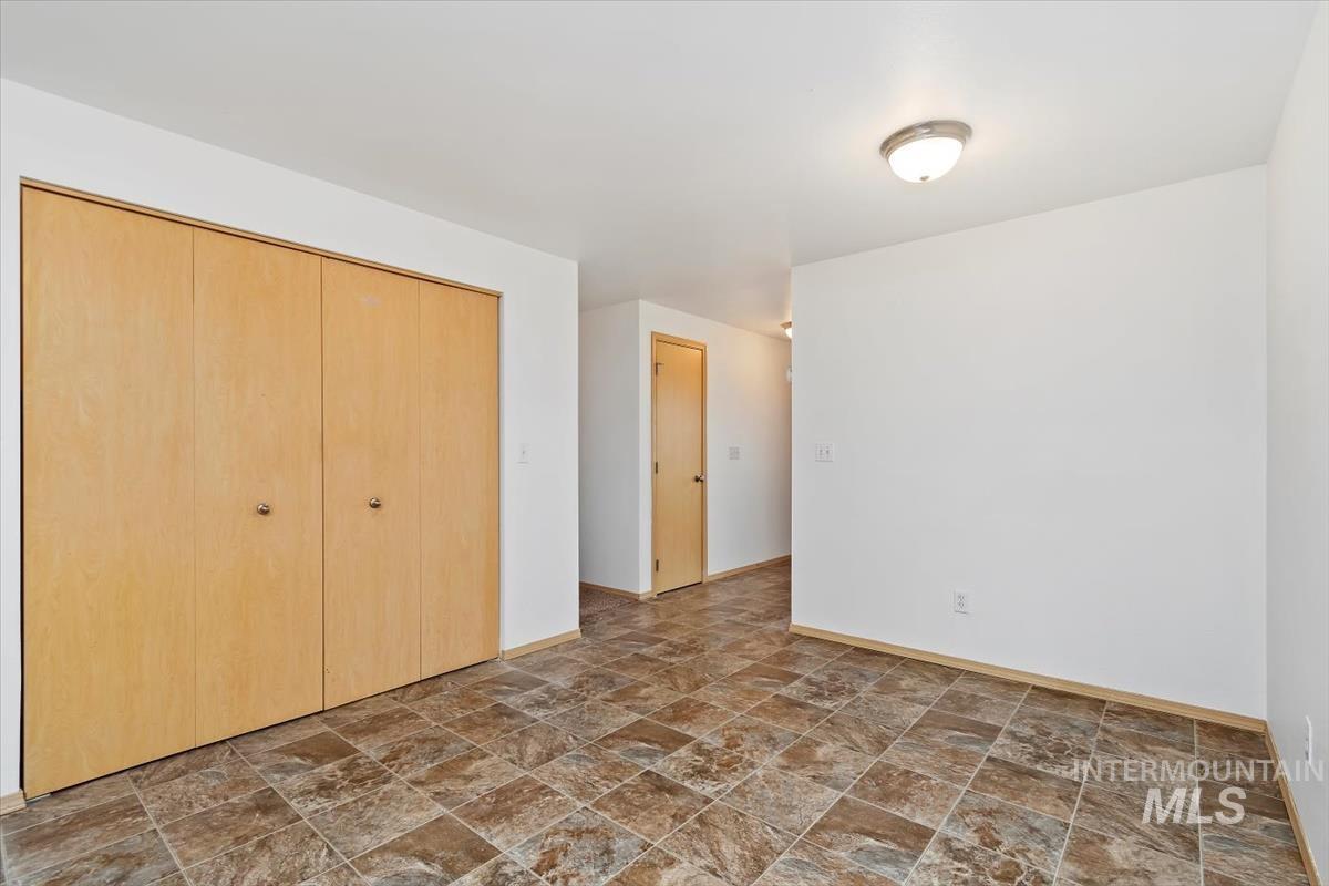 1051 Haas Road Weiser, ID 83672 - Photo 18 of 44 Unfurnished bedroom with stone finish flooring and a closet