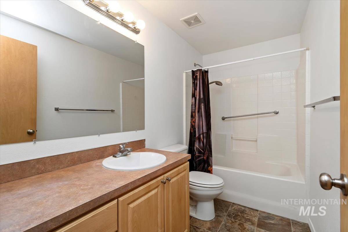 1051 Haas Road Weiser, ID 83672 - Photo 28 of 44 Full bathroom with vanity, shower / bath combination with curtain, and stone finish flooring