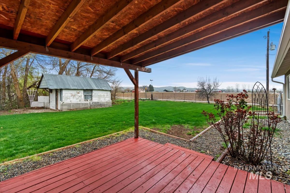 1051 Haas Road Weiser, ID 83672 - Photo 30 of 44 Wooden terrace featuring an outbuilding, a fenced backyard, and a mountain view