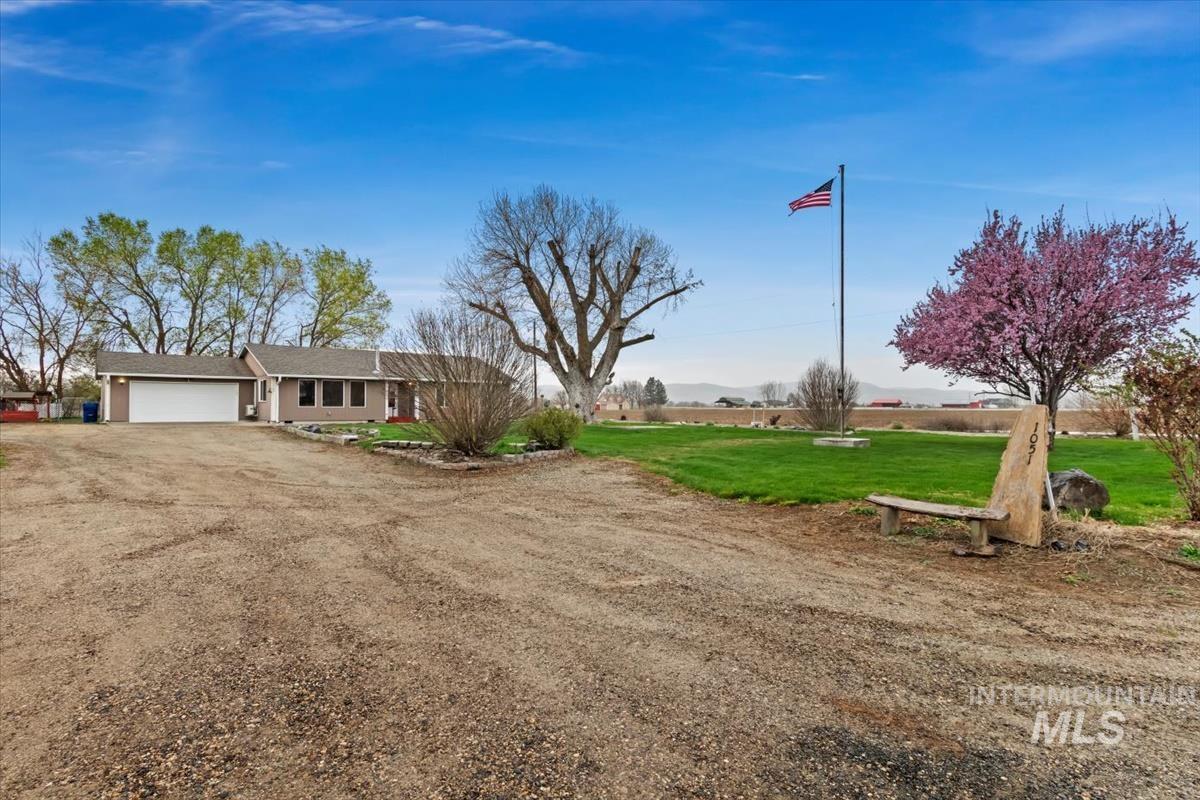 1051 Haas Road Weiser, ID 83672 - Photo 39 of 44 View of front facade featuring dirt driveway, an attached garage, and a front lawn