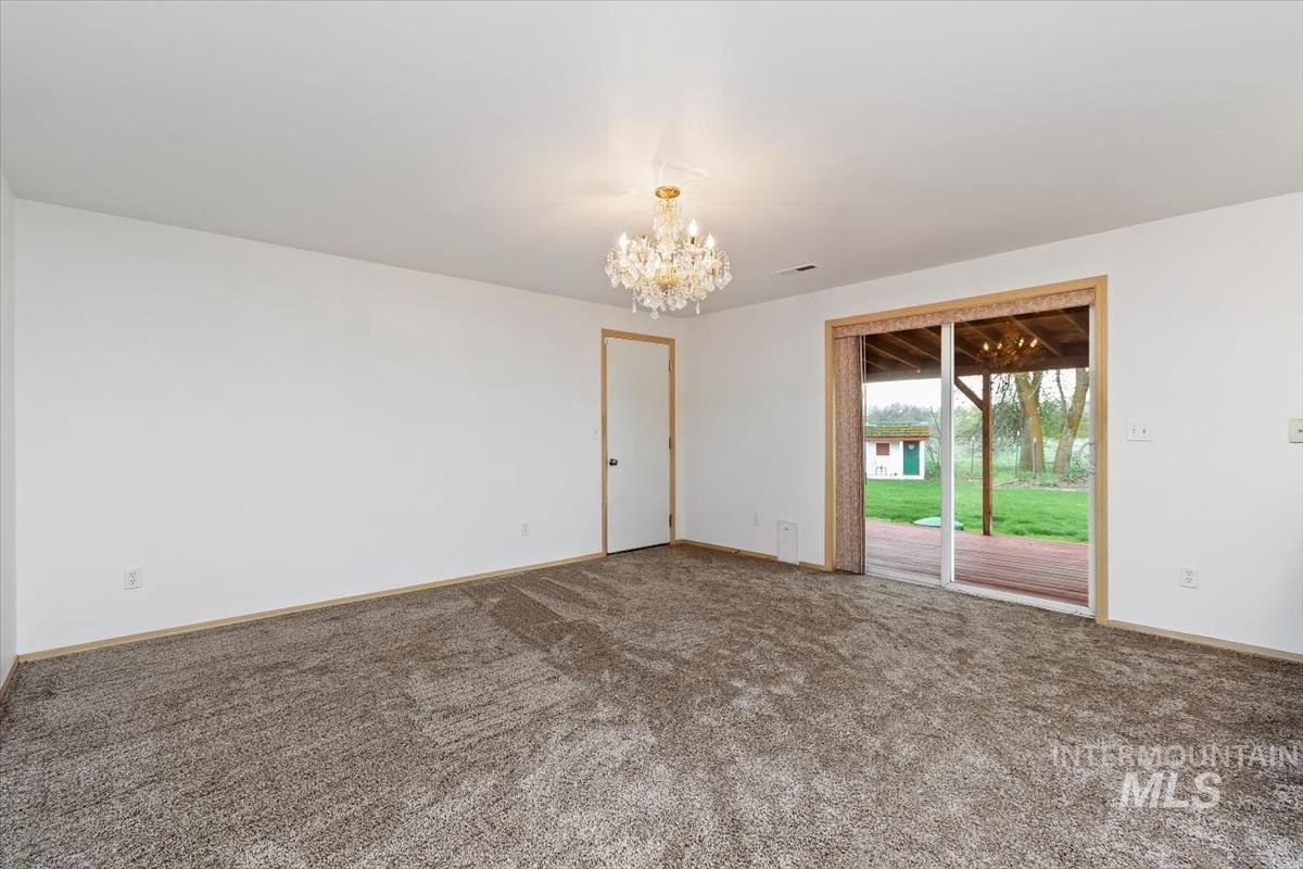 1051 Haas Road Weiser, ID 83672 - Photo 9 of 44 Carpeted empty room with a chandelier and baseboards