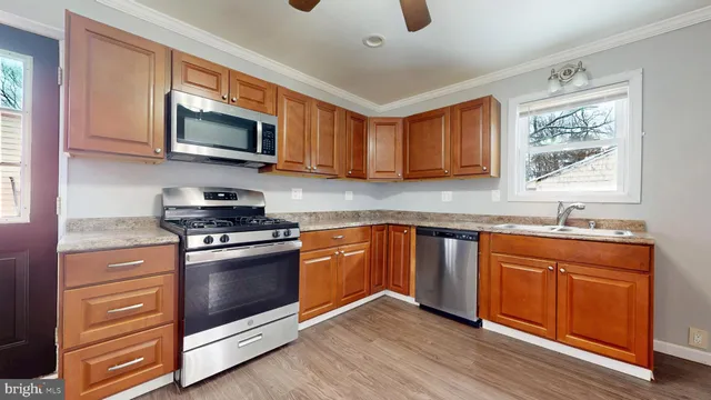 a kitchen with stainless steel appliances granite countertop a stove a sink and a microwave