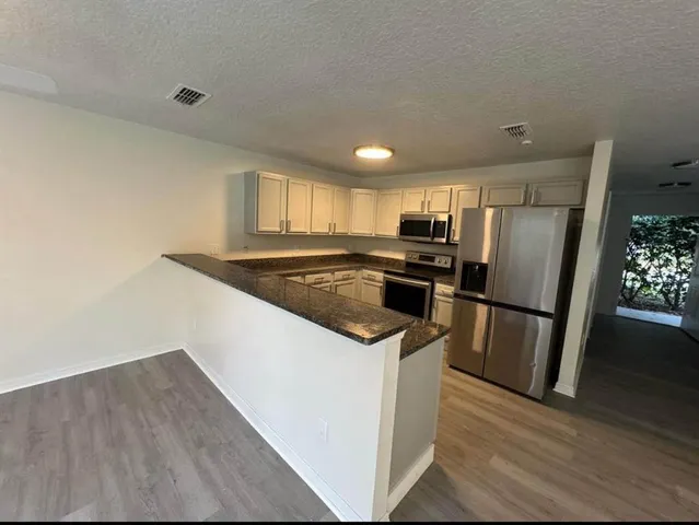 a kitchen with a refrigerator a stove a sink and a window