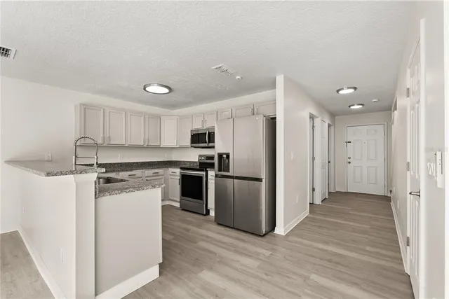 a kitchen with stainless steel appliances a refrigerator and a stove top oven