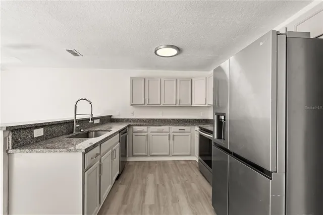 a kitchen with a sink stove and refrigerator