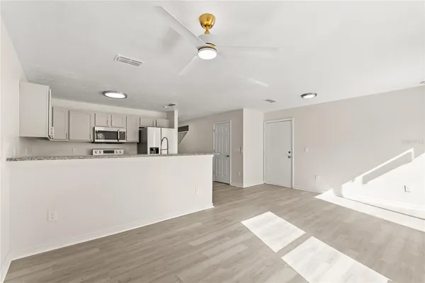 a view of kitchen with kitchen island microwave and wooden floor