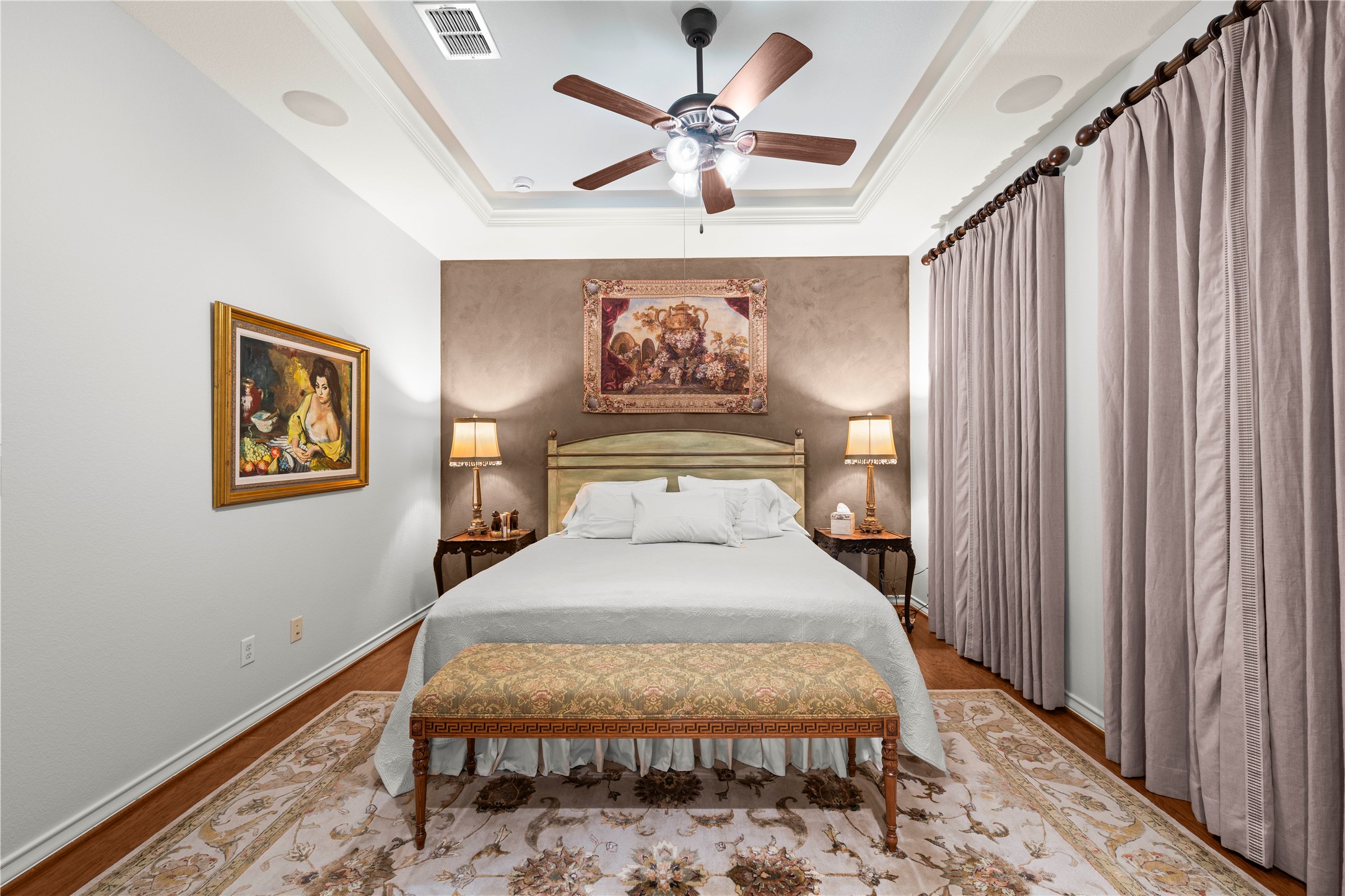 204 Adams Street Georgetown, TX 78628 - Photo 16 of 33 A recessed tray ceiling and rich wood flooring elevate this elegant primary bedroom.