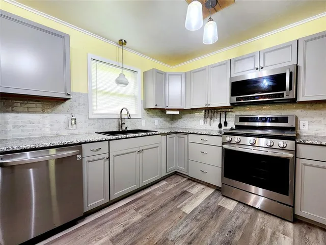a kitchen with a sink stove and microwave