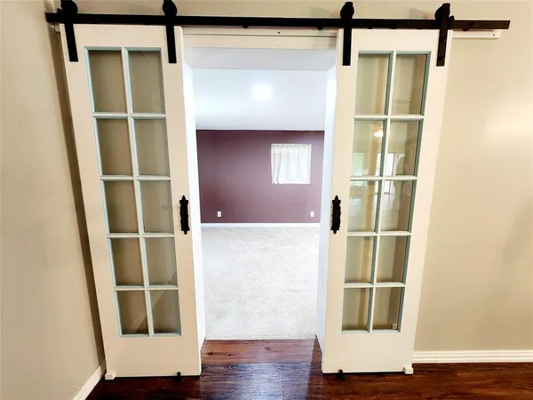 a room with wooden floor and windows