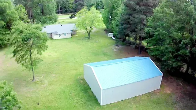 an aerial view of a house with a yard and trees