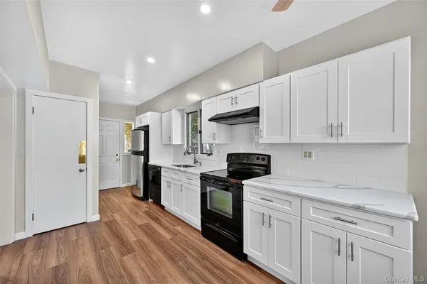 a kitchen with white cabinets stainless steel appliances and sink