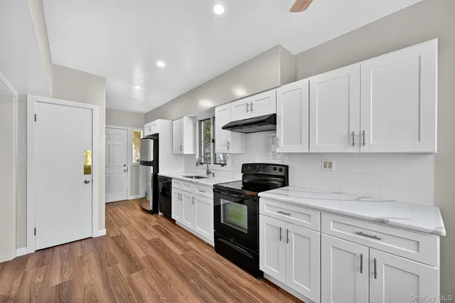 a kitchen with white cabinets stainless steel appliances and sink
