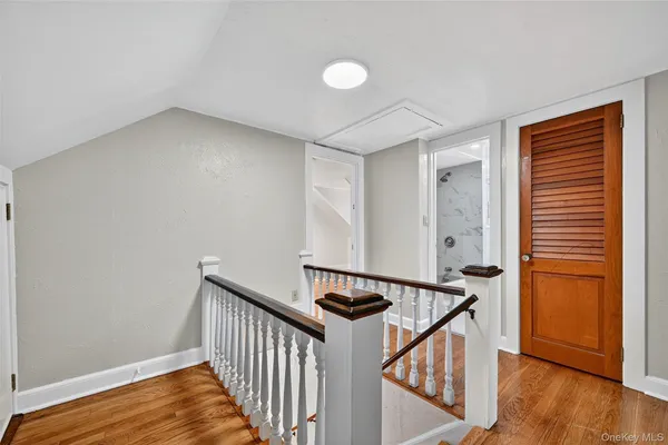a view of a hallway with wooden floor and stairs
