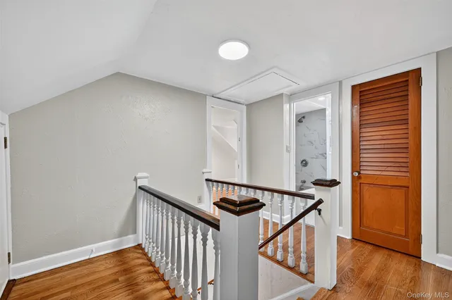 a view of a hallway with wooden floor and stairs
