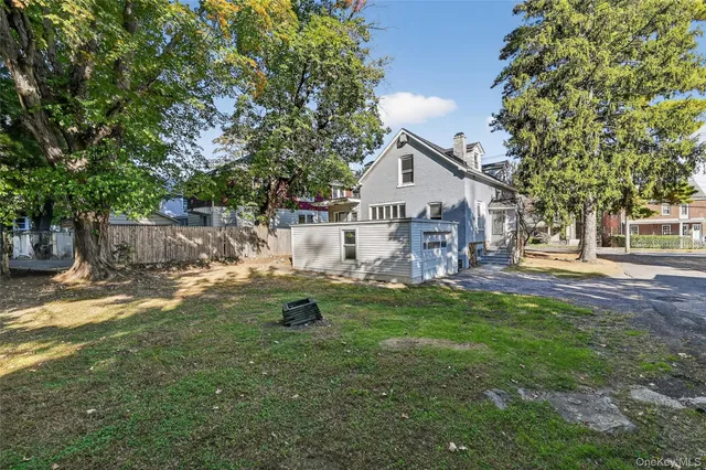 a backyard of a house with barbeque oven table and chairs