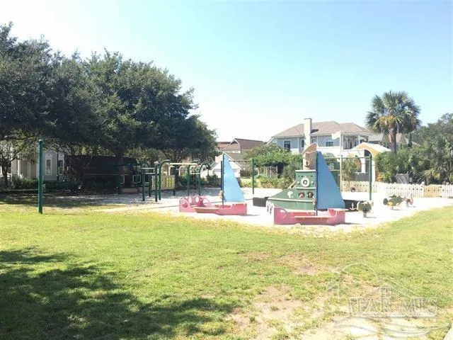 a view of swimming pool with lawn chairs and large trees