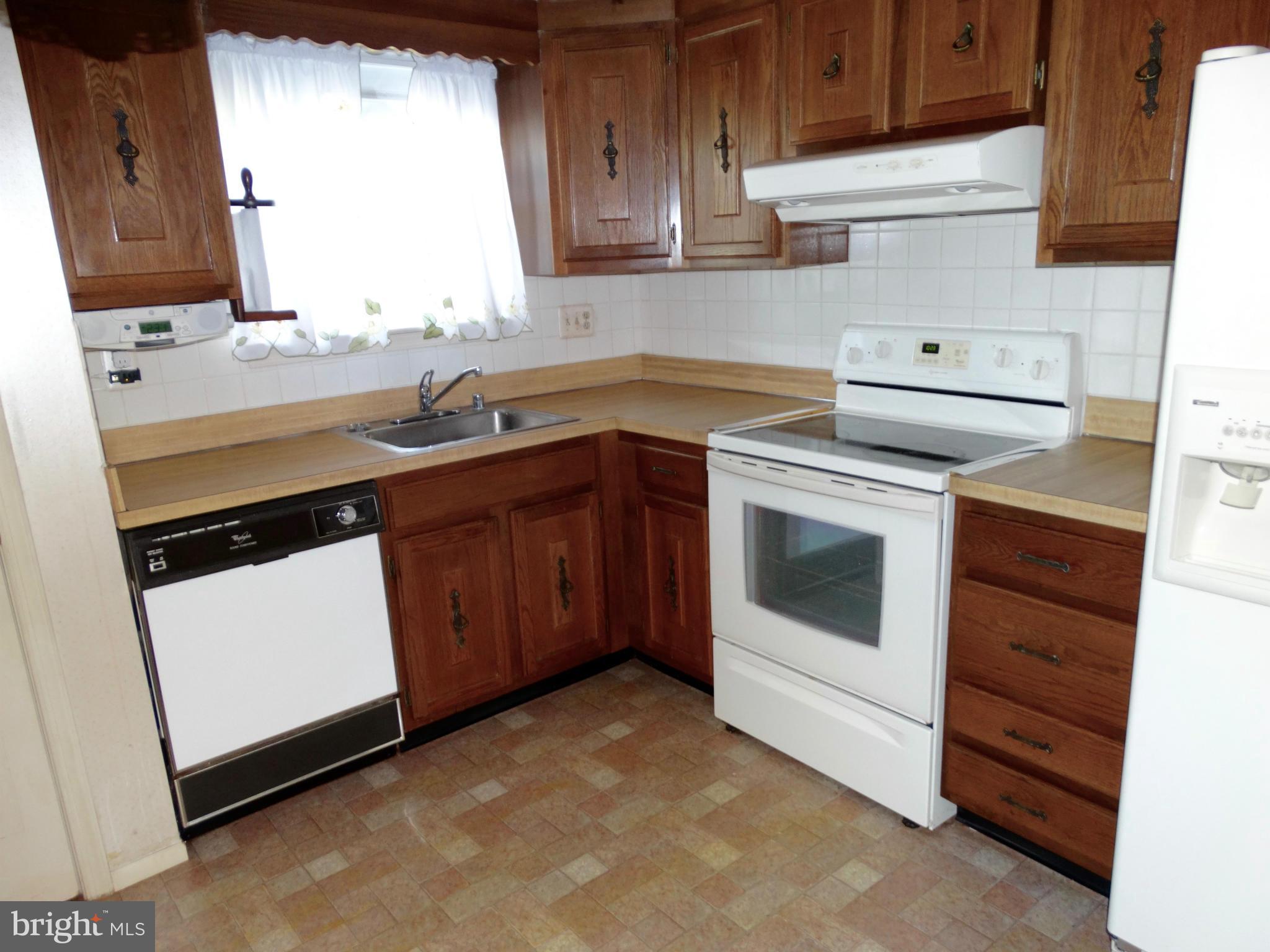 8204 Grainfield Road Severn, MD 21144 - Photo 4 of 30 a kitchen with a stove sink and cabinets