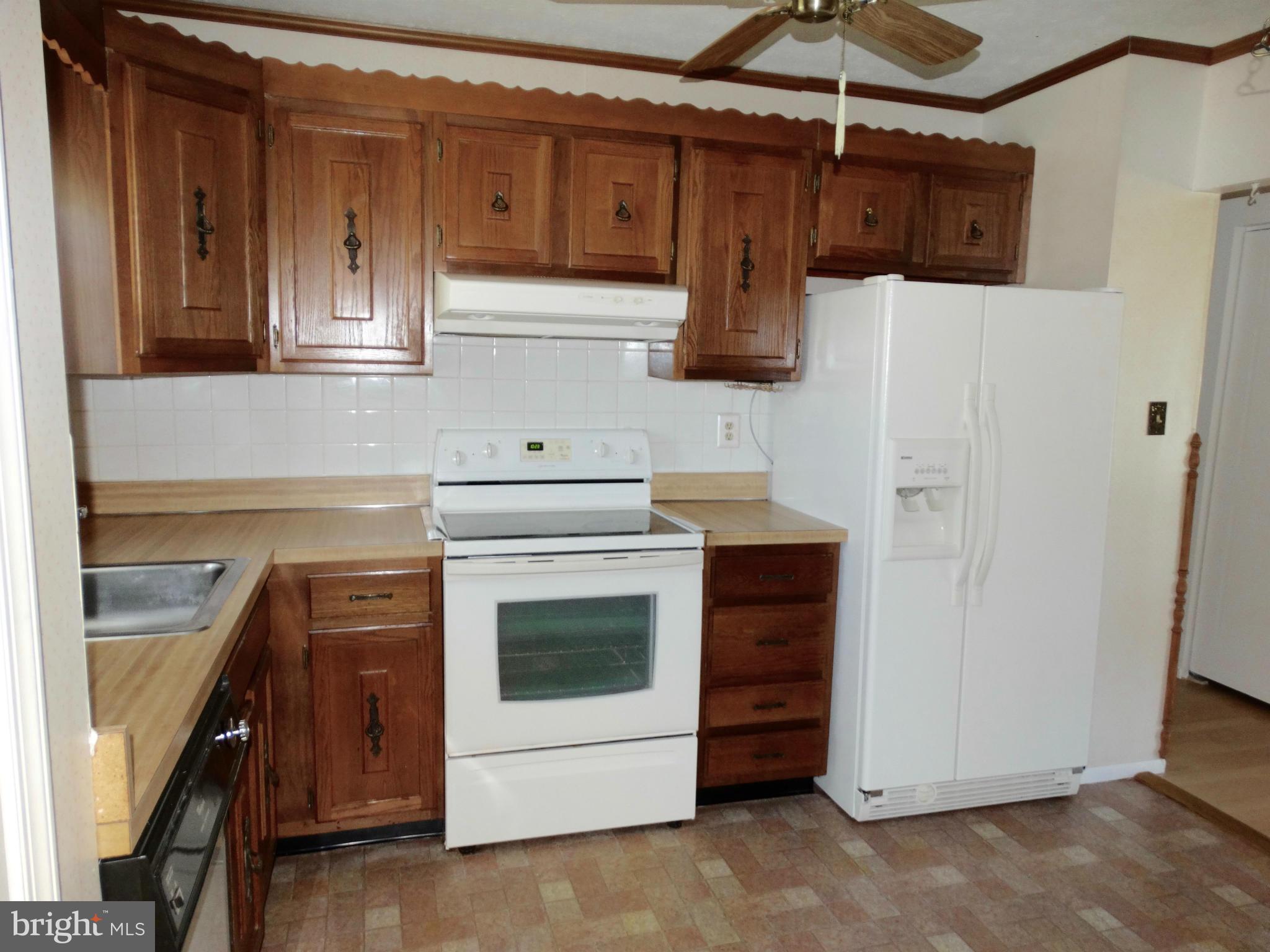 8204 Grainfield Road Severn, MD 21144 - Photo 5 of 30 a kitchen with cabinets and white appliances