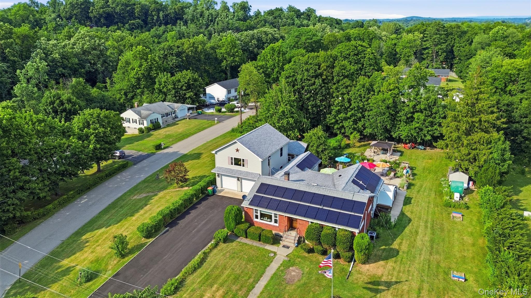 1 Hiko Place Fishkill, NY 12524 - Photo 2 of 41 Expansive property featuring a brick and siding exterior, solar panel installation, attached two-car garage, and a substantial green lawn