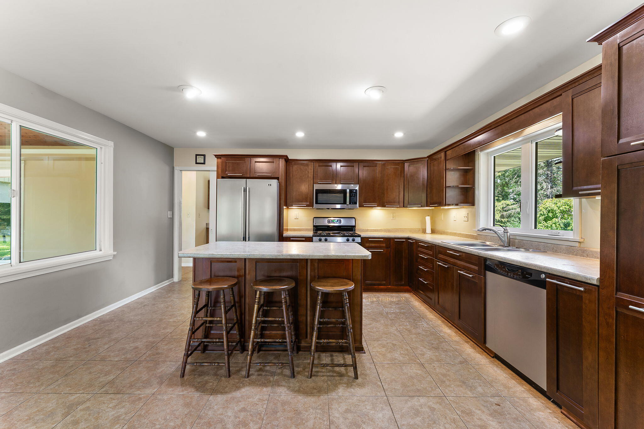 16280 Hendricks Street Lowell, IN 46356 - Photo 11 of 35 a kitchen with stainless steel appliances granite countertop table chairs sink and window