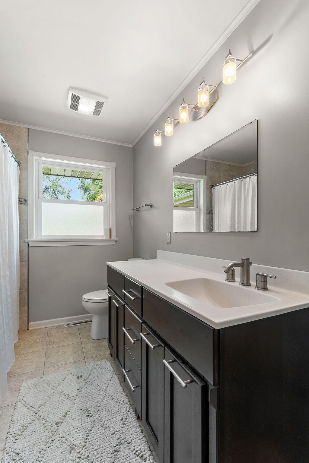 16280 Hendricks Street Lowell, IN 46356 - Photo 22 of 35 a bathroom with a sink a toilet a mirror and a window